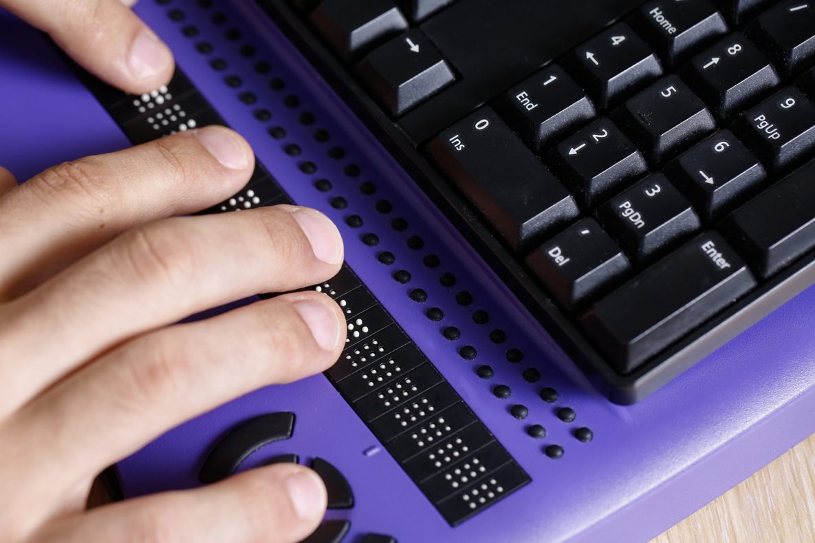 Un homme tapant sur un clavier braille