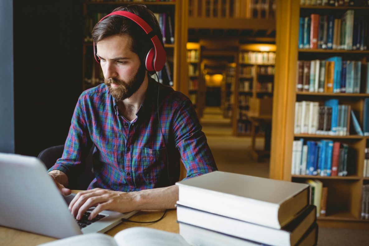 Un homme dans la bibliothèque avec des écouteurs  