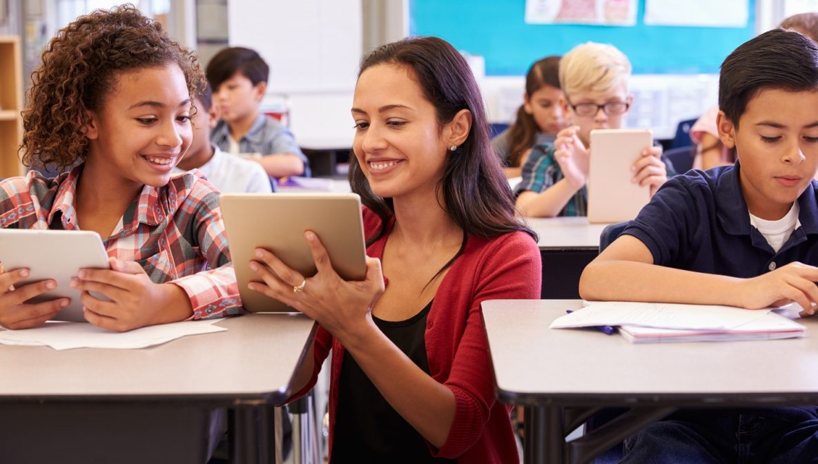 Un enseignant avec un iPad aide ses élèves
