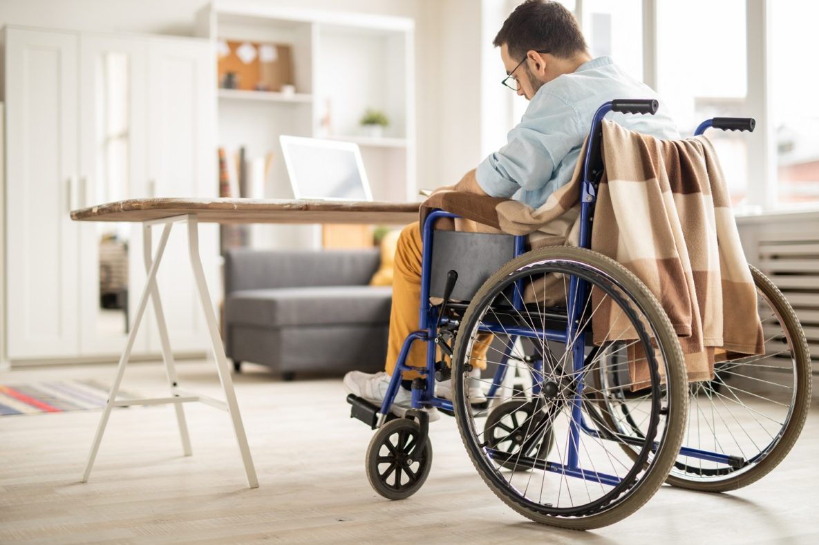 Un homme en fauteuil roulant à l'aide d'un ordinateur portable