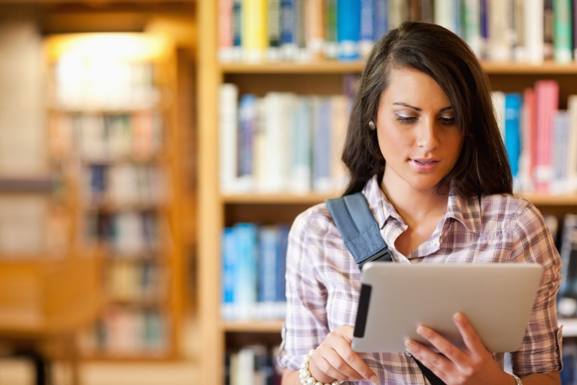 Un homme utilisant un ipad dans la bibliothèque