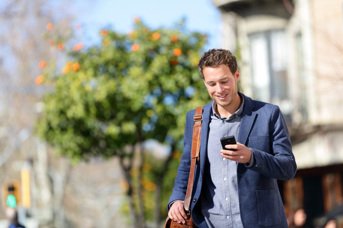 un homme marchant avec son smartphone