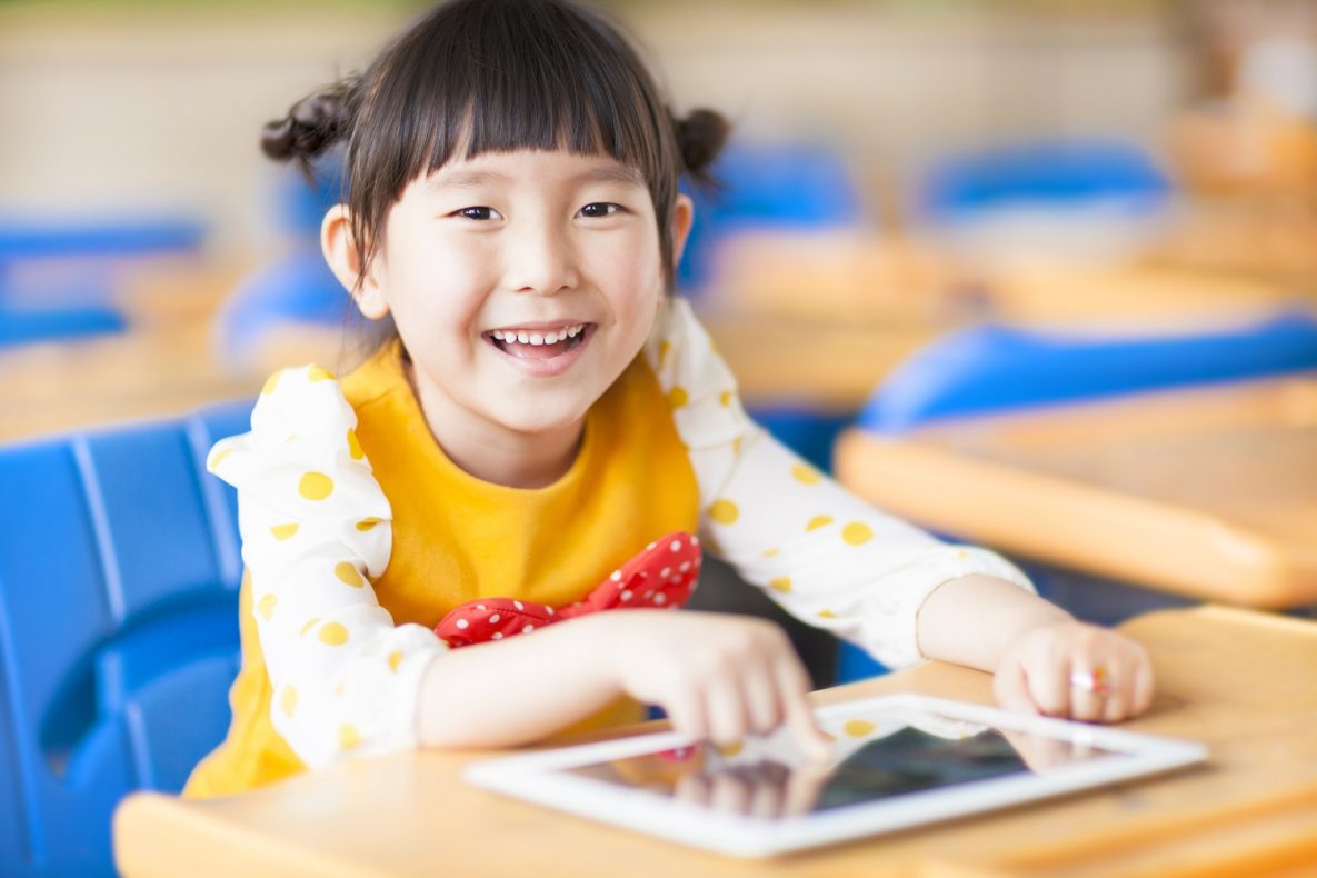 Une jeune fille souriante avec un ipad