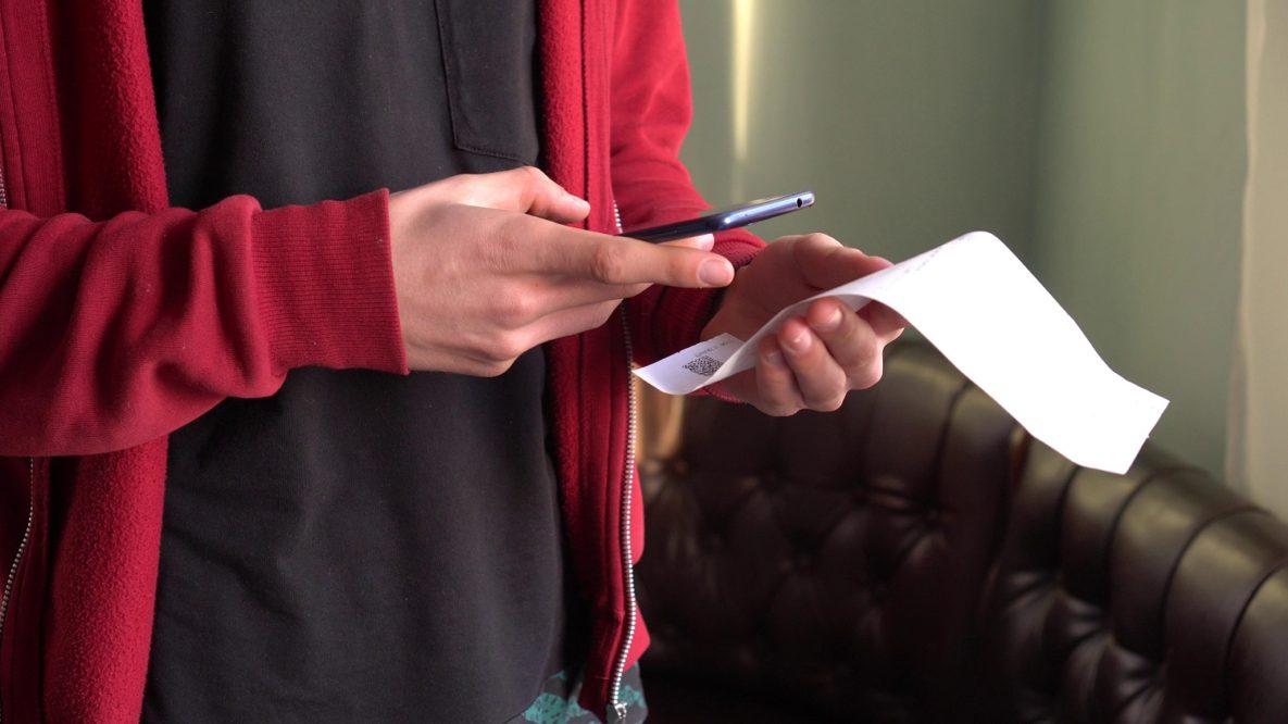 Un homme à l'aide d'un smartphone pour numériser un reçu
