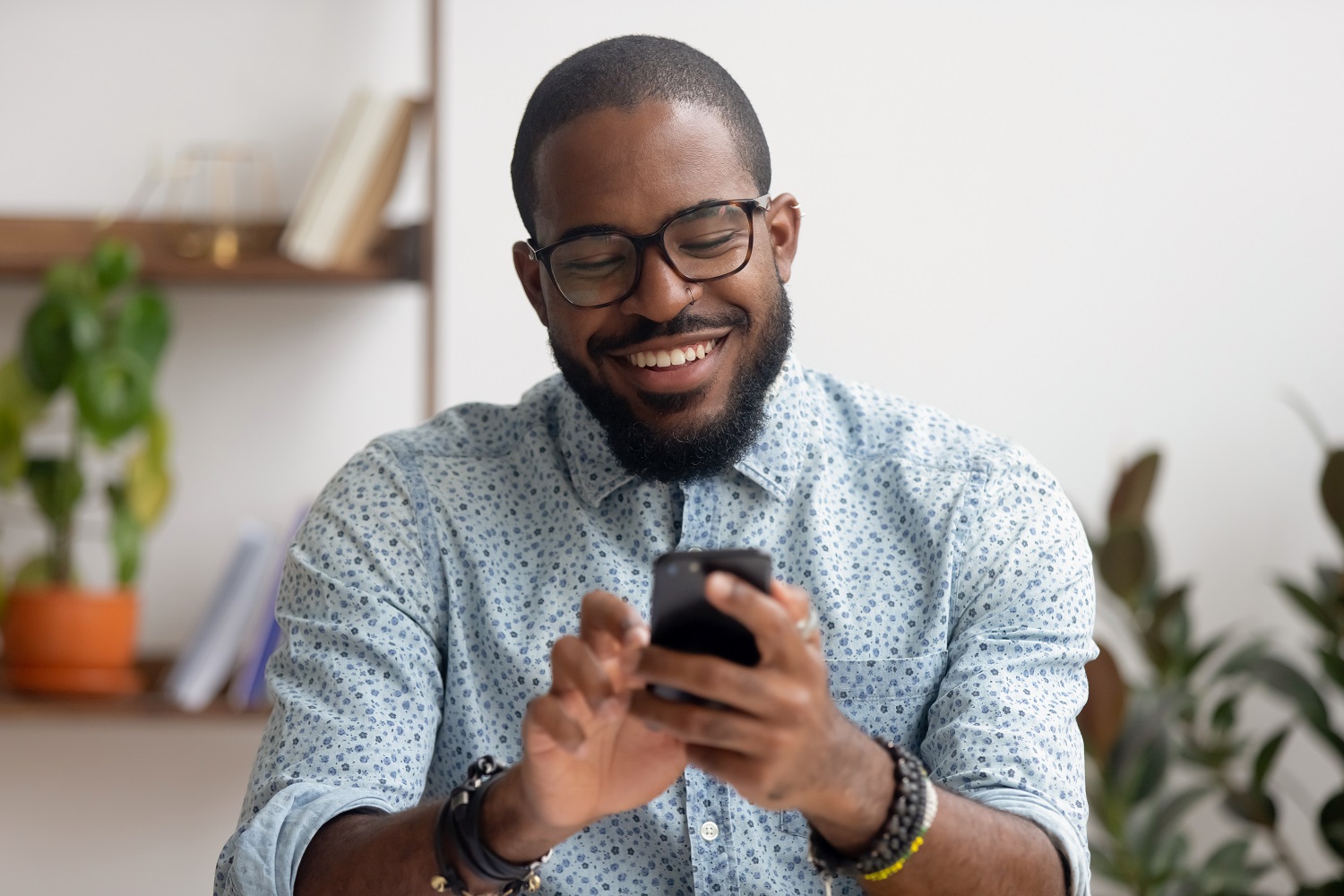 Un homme d'affaires souriant à l'aide de son smartphone