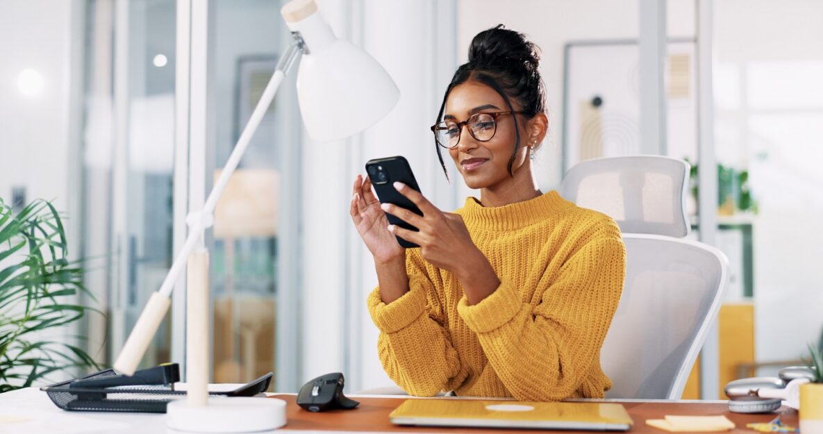 une femme utilise son smartphone au travail