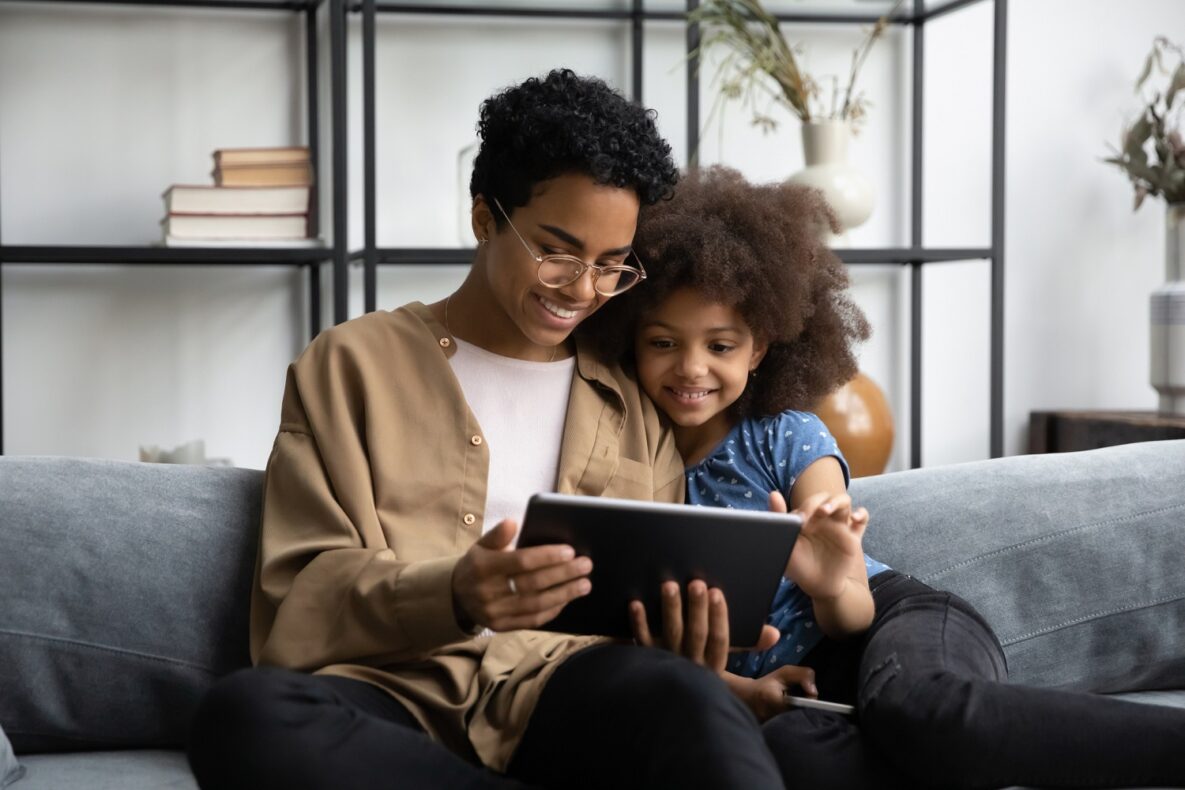 une femme et son enfant regardant leur tablette
