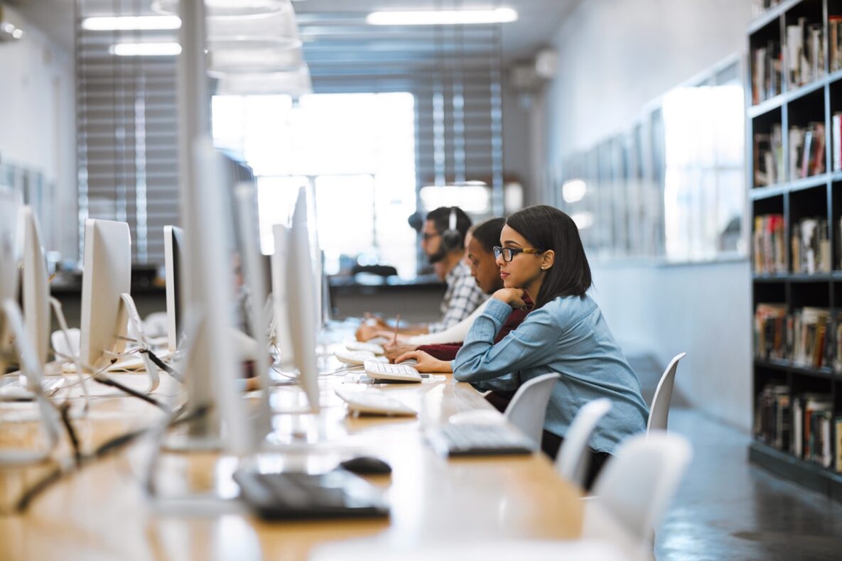 une étudiante utilisant son ordinateur en classe